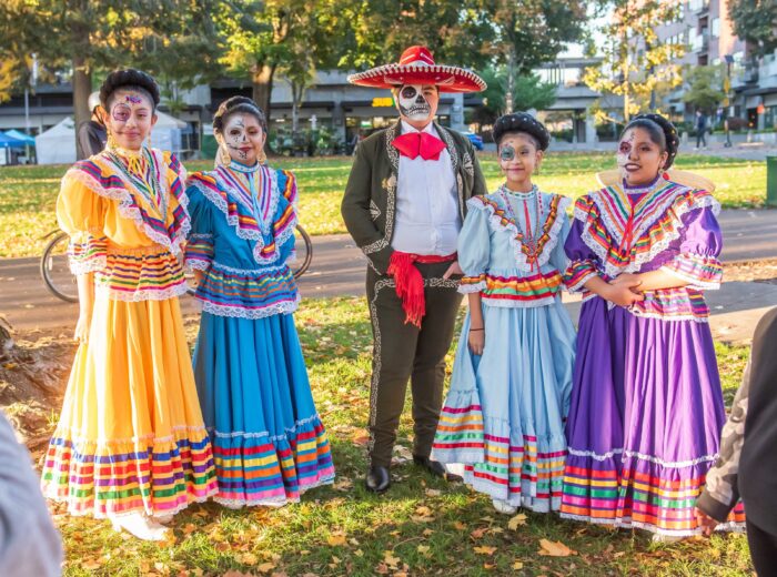 Dancers smile at the camera before a Dia de Muertos performance