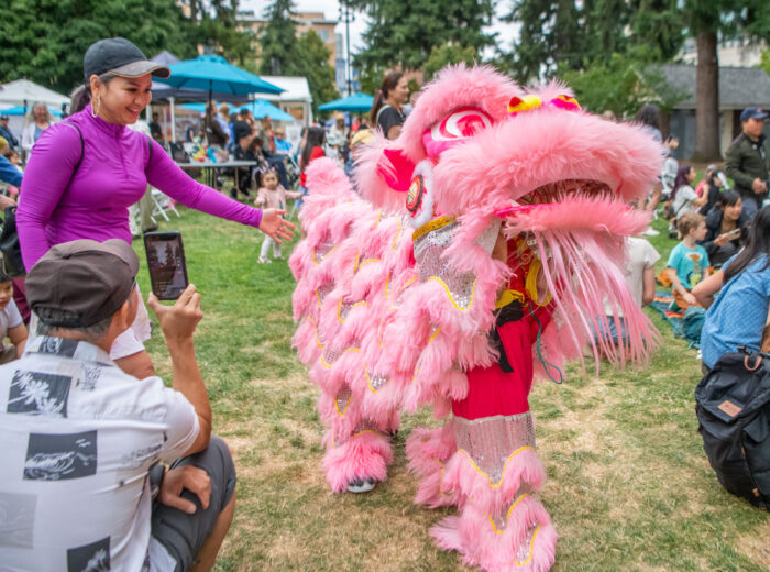 Bright pink lion dancer at an outdoor festival.
