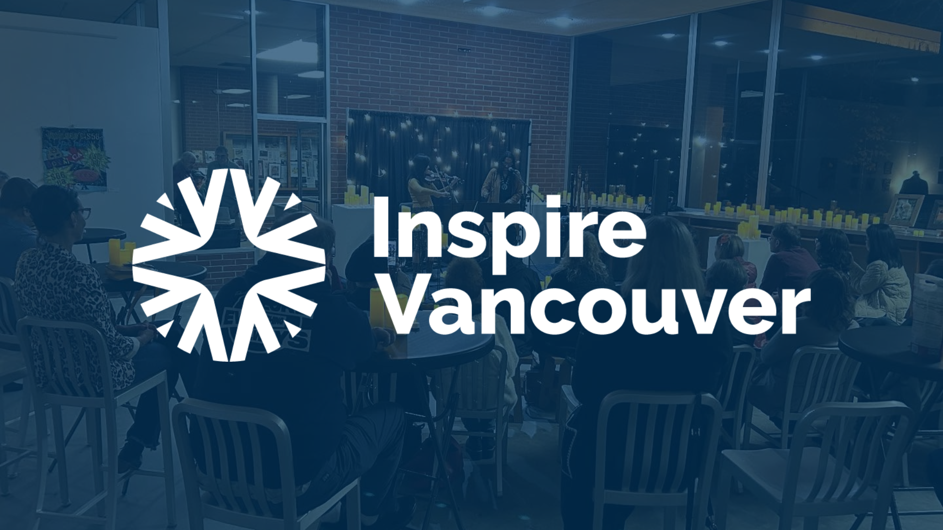 People watching a candlelit music performance in the front gallery of the Vancouver arts hub with a dark blue color overlay and white Inspire Vancouver logo